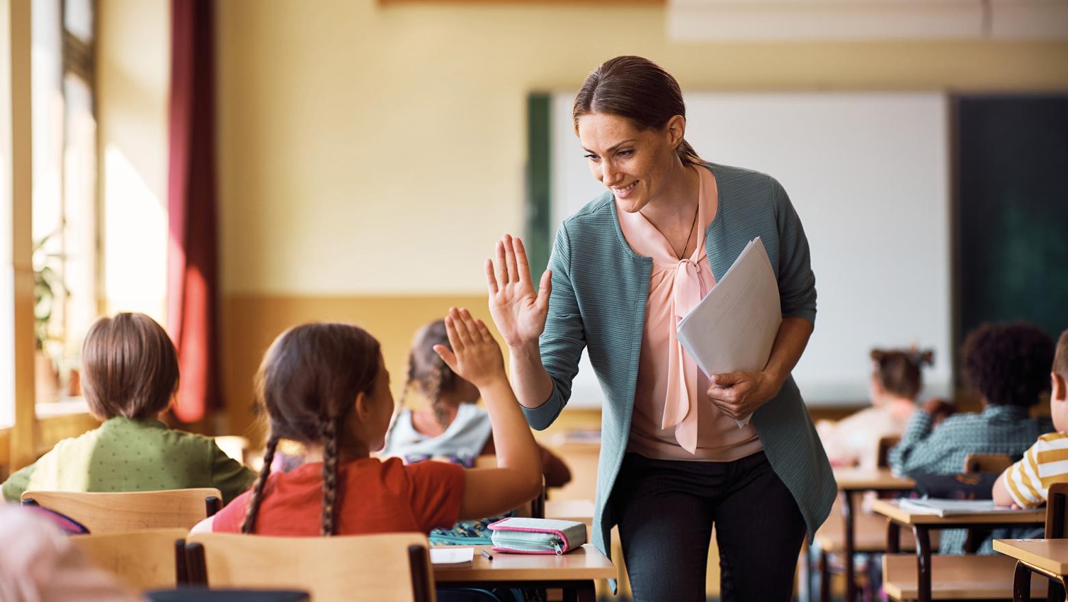 Eine Lehrerin geht durch ein Klassenzimmer